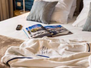 a bed with a book and two books on it at Novotel Gdańsk Marina in Gdańsk