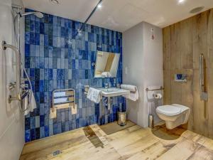 a bathroom with a toilet and a sink at Novotel Gdańsk Marina in Gdańsk