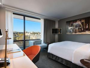 a hotel room with a bed and a balcony at Pullman Paris Tour Eiffel in Paris