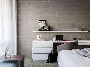 a bedroom with a bed and a desk with a laptop at Pullman Paris Tour Eiffel in Paris