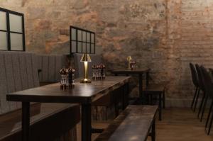a room with tables and chairs and a brick wall at CoDE Pod – The CoURT - Edinburgh in Edinburgh