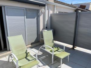 2 stoelen op een balkon met jaloezieën bij Dúplex apartment en Peñíscola in Peñíscola