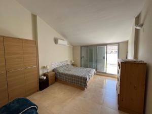 een slaapkamer met een bed en een groot raam bij Dúplex apartment en Peñíscola in Peñíscola