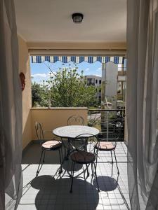 un tavolo e delle sedie su un balcone con una finestra di Casa-vacanze mare a Isca Marina