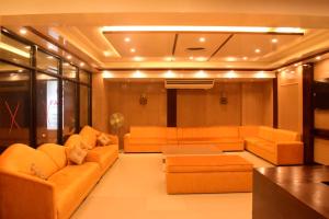a living room with orange couches and a table at Falcon Beach Resort in Cox's Bazar