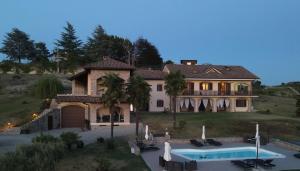 a large house with a swimming pool in front of it at LA CASA IN CAMPAGNA esclusiva in Calosso
