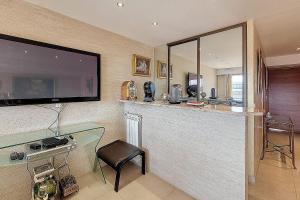eine Küche mit einer Bar mit einem Fernseher an der Wand in der Unterkunft HENRI CAMILLE REAL ESTATE - Kent - Huge 2 bedrooms appt - 5 min Croisette in Cannes