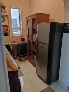 a kitchen with a refrigerator next to a cabinet at Villa Uppugama in Etagama