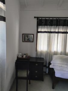 a bedroom with a bed and a desk and a window at Villa Uppugama in Etagama