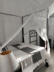 a bedroom with a white bed with a canopy at Villa Uppugama in Etagama