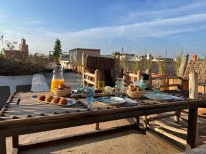 a wooden table with food and drinks on a patio at Riad Maiya in Marrakesh