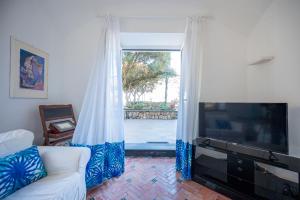 Villa Serao Cottage Camilla by MyVillaCollection في ايسكيا: غرفة معيشة مع أريكة ونافذة كبيرة