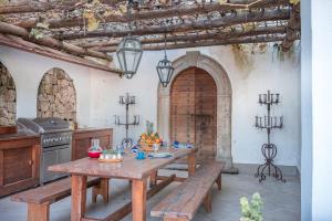 Villa Serao Cottage Camilla by MyVillaCollection في ايسكيا: مطبخ مع طاولة خشبية وكراسي في الغرفة