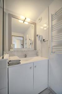 a white bathroom with a sink and a mirror at Edouard - Piscine-Parking - VCA in Cannes