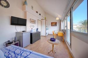 a room with a bed and a tv and a table at Edouard - Piscine-Parking - VCA in Cannes