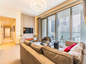 a living room with a couch and a large window at the London Condo - Forte Downtown Dubai in Dubai