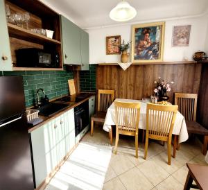 a kitchen with a table with chairs and a sink at Bonjour Vendégház in Nyíregyháza