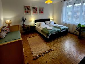 a bedroom with a bed and a couch in it at Bonjour Vendégház in Nyíregyháza