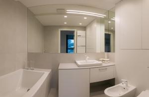 a bathroom with a sink and a tub and a toilet at Jurata Residence in Jurata +109 photos