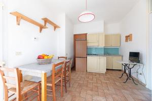 Una cocina y un comedor con mesa y sillas. en Appartamenti Le Prade - Goelba, en Portoferraio 31 fotos más