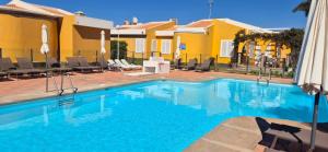 a swimming pool in front of a villa at HANDICAP 7 Bungalow 4 in San Bartolomé