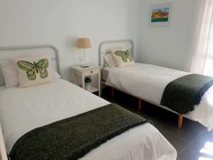 a bedroom with two beds and a table with a lamp at HANDICAP 7 Bungalow 4 in San Bartolomé +9 photos