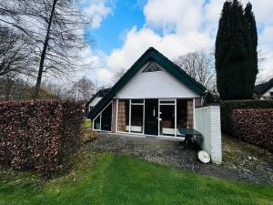 ein kleines weißes Haus mit einem grünen Hof in der Unterkunft Bungalowpark Simpelveld - Delta 154 in Simpelveld
