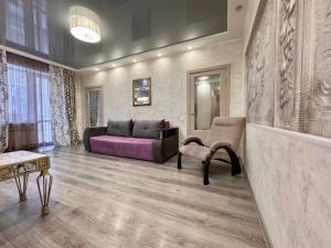 a living room with a couch and a table at ApartPoltava Елегантна ДВОКІМНАТНА студія з панорамою на театр Гоголя, ЦУМ, Фіскальний ЧЕК in Poltava
