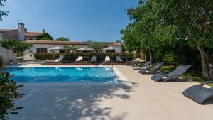 basen z leżakami obok domu w obiekcie Villa LV by Villas Holiday w mieście Fiorini