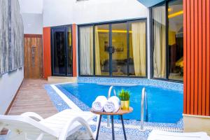 a swimming pool with white chairs and a table with towels at The Land Resort in Riyadh
