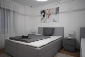 a white bedroom with a bed with avertisementatronatronstrationstrationstration at Moderne Ferienwohnung mit Kochinsel in Sinsheim Zentral ruhig und Netflix - Erstbezug WeHome Komfort in Sinsheim +47 photos