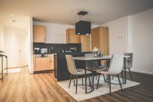 a kitchen with a dining room table and chairs at Moderne Ferienwohnung mit Kochinsel in Sinsheim Zentral ruhig und Netflix - Erstbezug WeHome Komfort in Sinsheim