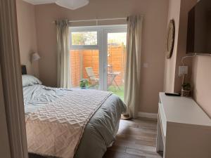 a bedroom with a bed and a sliding glass door at Lawson Lodge in Alveston