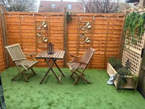 a patio with two chairs and a table and a fence at Lawson Lodge in Alveston