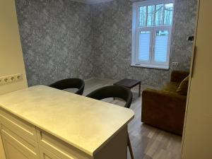 a kitchen with a table and chairs and a couch at An apartment by the Emajõgi River in Tartu