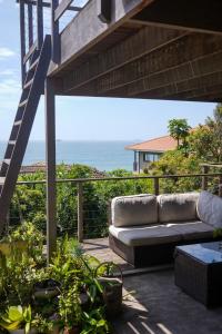 a couch on a patio with the ocean in the background at Westbrook Beach Haven in Westbrook