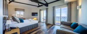 a bedroom with a large bed and a couch at Hôtel de la Plage - Saint Jean de Luz in Saint-Jean-de-Luz