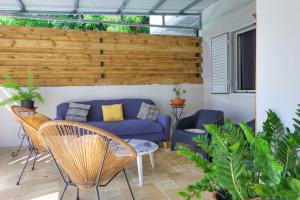a living room with a blue couch and chairs at La Villa M&M - entre Mer et Montagne - La Possession in La Possession