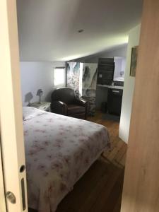 Domaine Papillon في Talais: غرفة نوم بها سرير ومكتب وكرسي