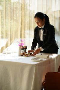 a woman in a tuxedo sitting at a table at The Biltmore Hotel Villas Dubai in Dubai +65 photos