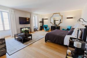 a bedroom with a bed and a mirror and blue chairs at Bastide Saint Julien in La Celle