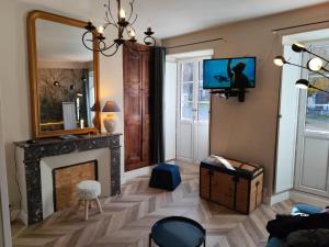 a living room with a fireplace and a mirror at Appartement Place des Eaux Bonnes in Eaux-Bonnes