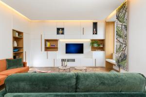 a living room with a green couch and a tv at Moon River Luxury Apartment in Rome