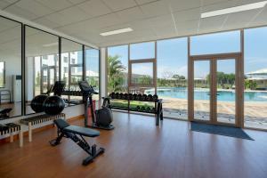 a gym with fitness equipment and a swimming pool at Protea Hotel by Marriott Lusaka International Airport in Lusaka
