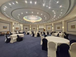 a banquet hall with tables and chairs in a room at Mena Holiday Beach Resort Half Moon in Half Moon Bay