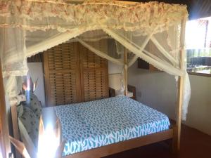 a bedroom with a bed with a canopy at STYLE MALGACHE et TOUT CONFORT in Nosy Be
