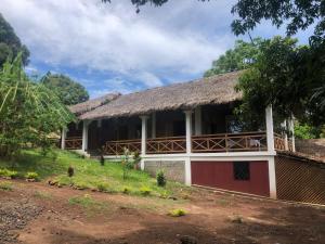 a house with a thatched roof and a yard at STYLE MALGACHE et TOUT CONFORT in Nosy Be