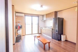 a kitchen with a refrigerator and a table in it at hasunumacottageA in Hasunuma