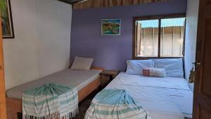 a small room with two beds and a window at Anez Cabin'S in Cabuya