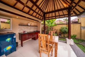 an outdoor kitchen with a wooden table and a counter at The Kampung Ubud Villa in Ubud